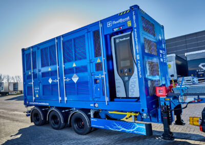 Mobiler Energiecontainer von FleetBoost auf einem Trailer mit integrierter Ladeeinheit, aufgestellt auf einem Logistikgelände zur flexiblen Stromversorgung und Ladeinfrastruktur.