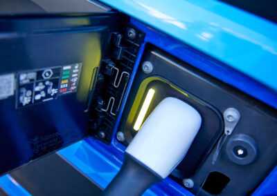 Ladestecker eines Elektrofahrzeugs ist an eine Ladebuchse angeschlossen, sichtbar ist eine aktive Statusanzeige an der Ladeeinheit eines mobilen Energiecontainers.