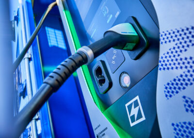 Detailansicht einer Schnellladeeinheit von FleetBoost mit angeschlossenem Ladekabel und beleuchteter Statusanzeige für den laufenden Ladevorgang.