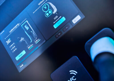 Detailansicht eines Touchscreens an einer Ladeeinheit eines mobilen Energiecontainers von FleetBoost, der den aktuellen Ladevorgang und Ladeparameter eines Elektrofahrzeugs anzeigt.